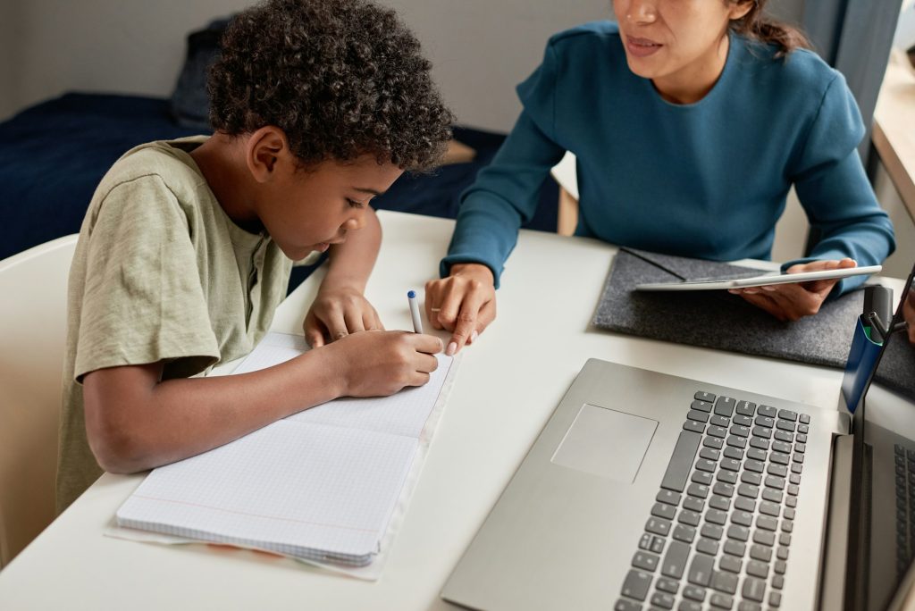 Tutor helping boy with school subject